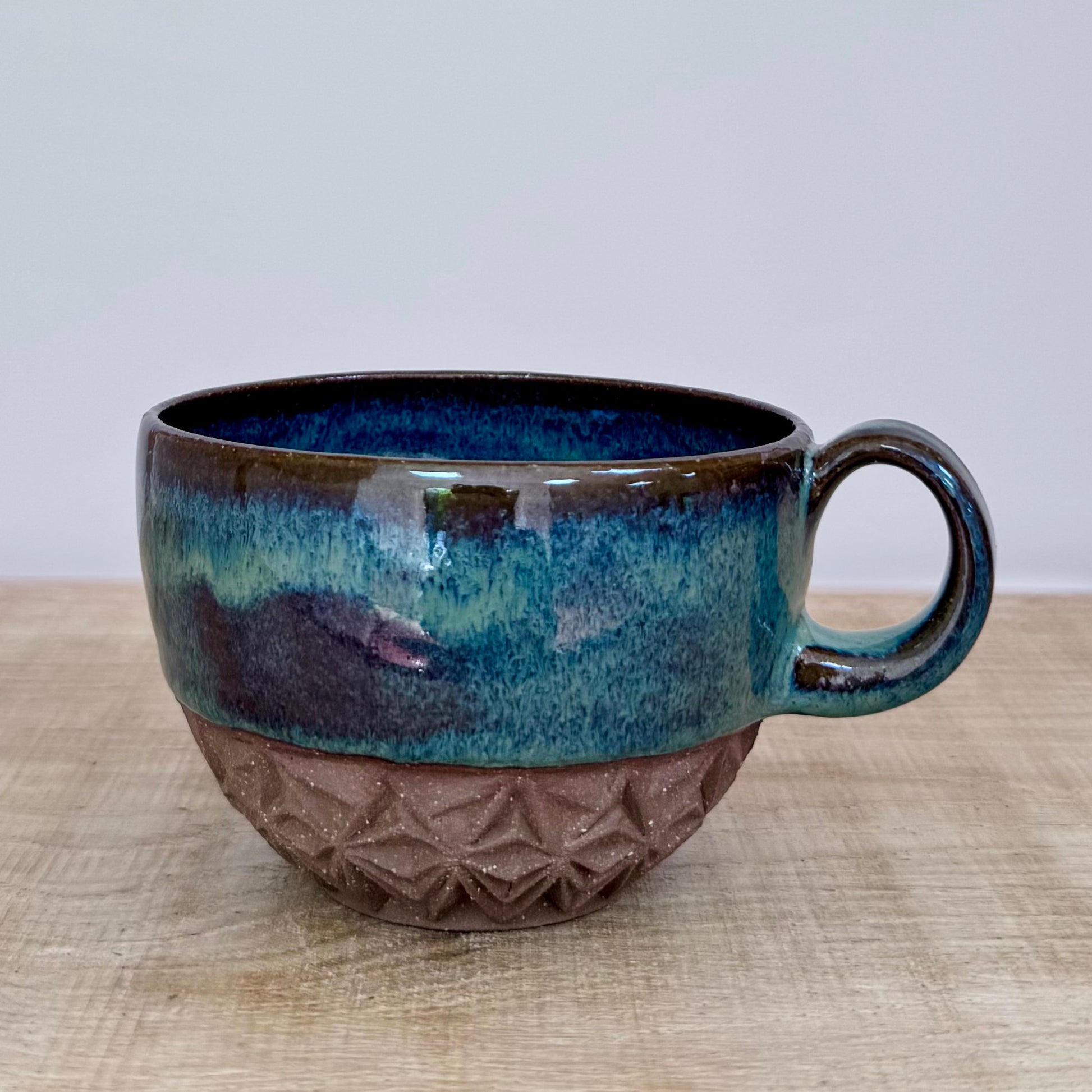 Handmade ceramic cappuccino cup carved green close up
